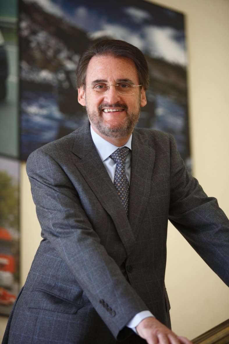Jaime Revilla sonriente, con traje gris de cuadros, apoyado en una barandilla