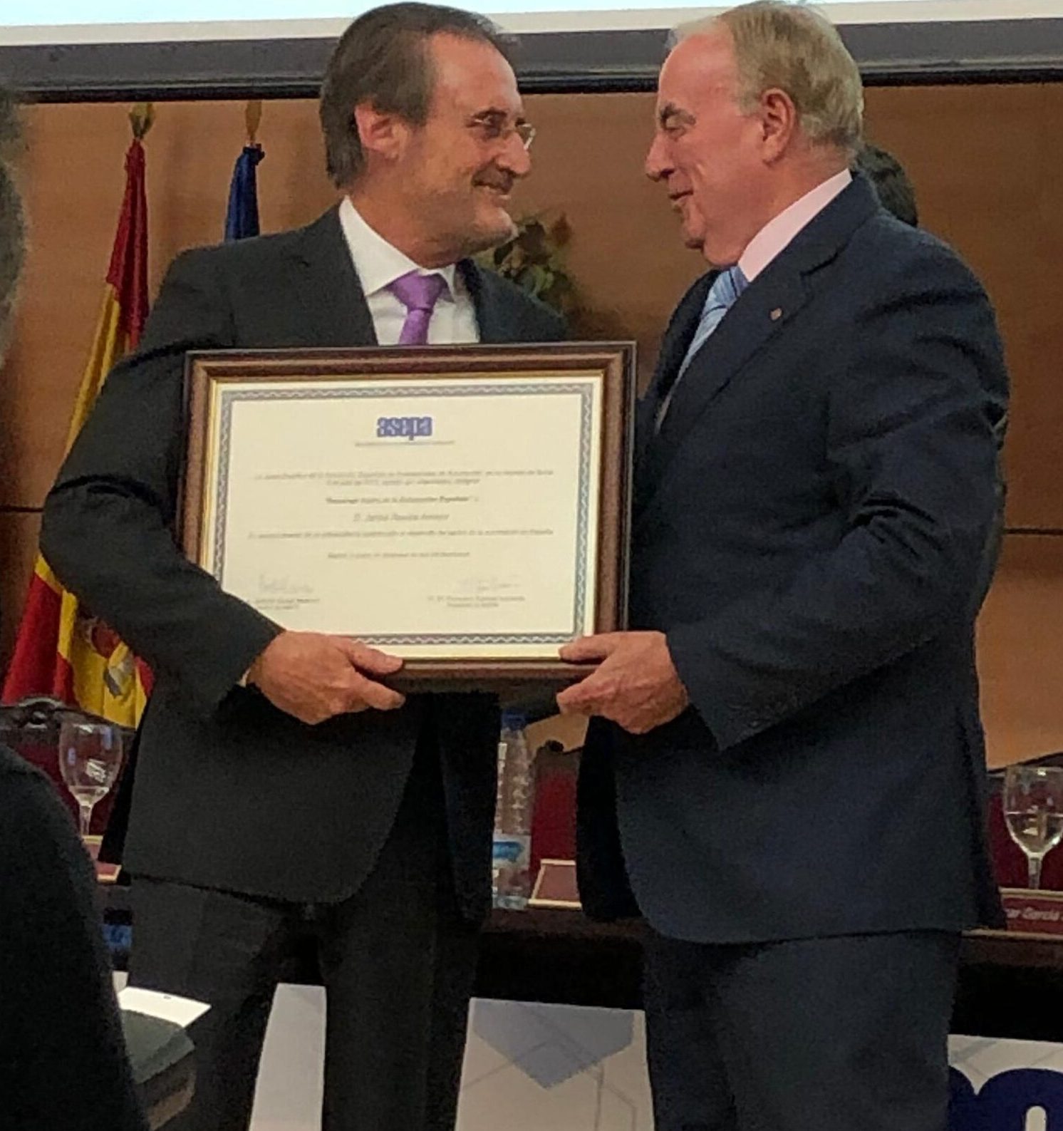 Jaime Revilla recibe un diploma enmarcado y sonríe