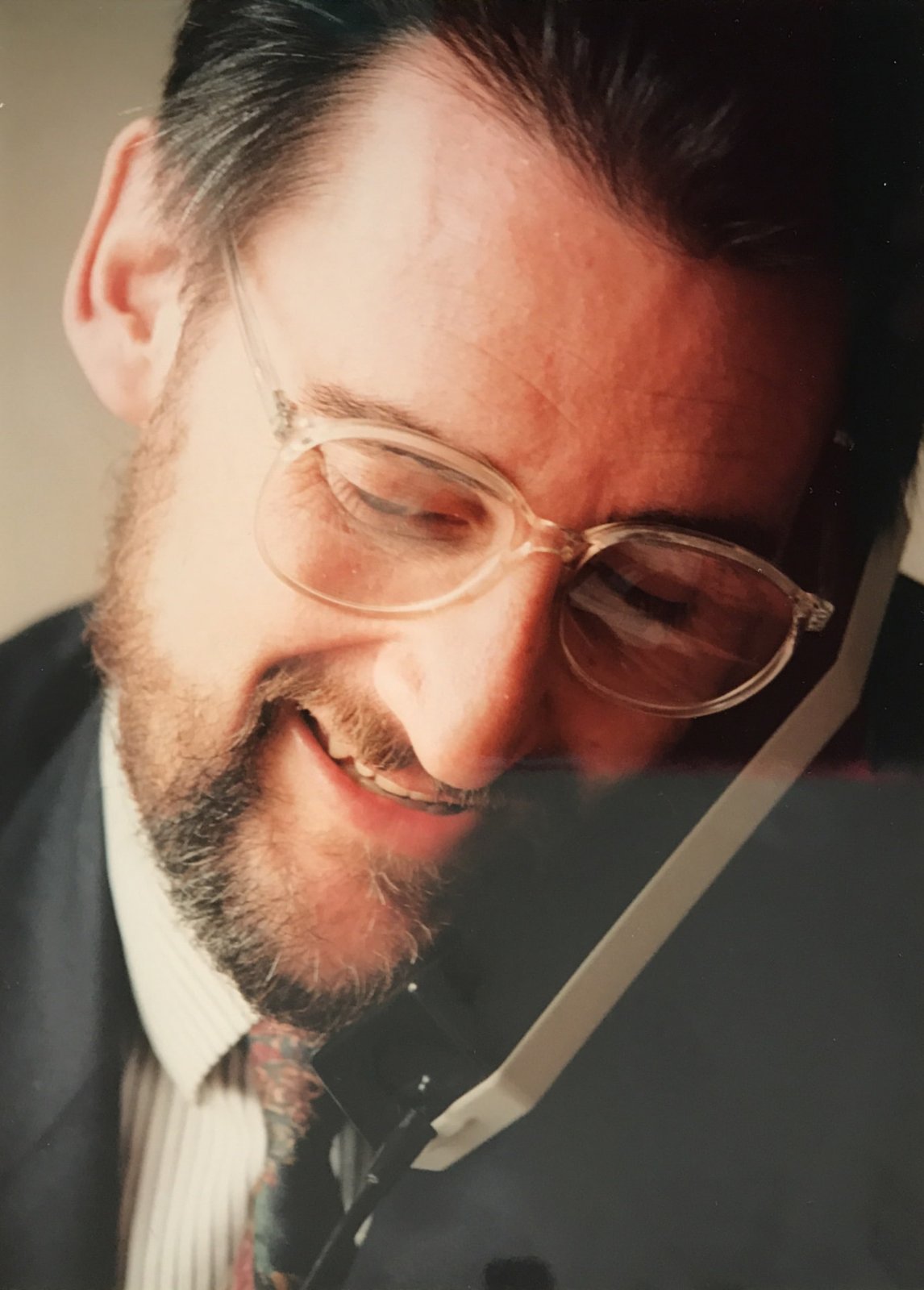 Primer plano de Jaime Revilla sonriendo mientras habla por teléfono