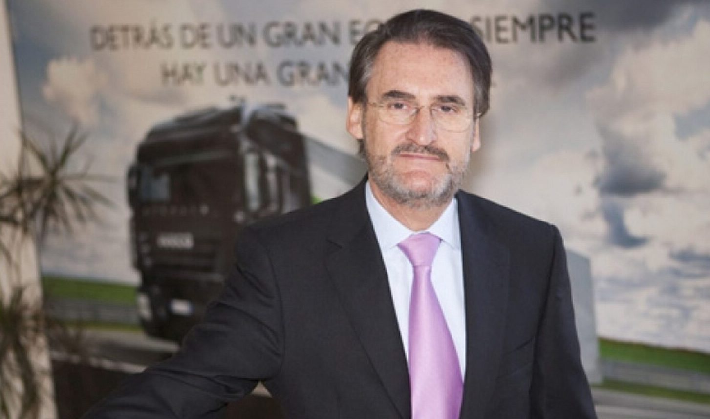 Jaime Revilla sonriente delante de un cartel con un camión