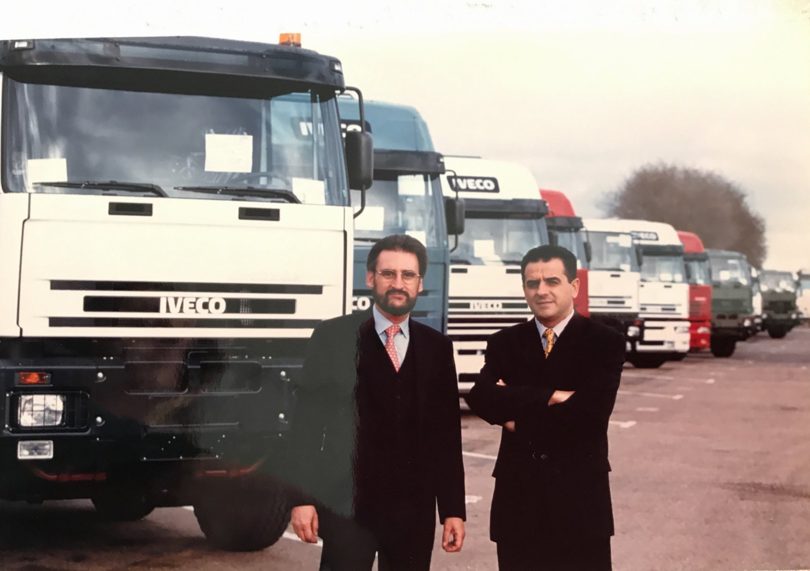 Jaime Revilla y Ramón Valdivia delante de una larga fila de camiones Iveco