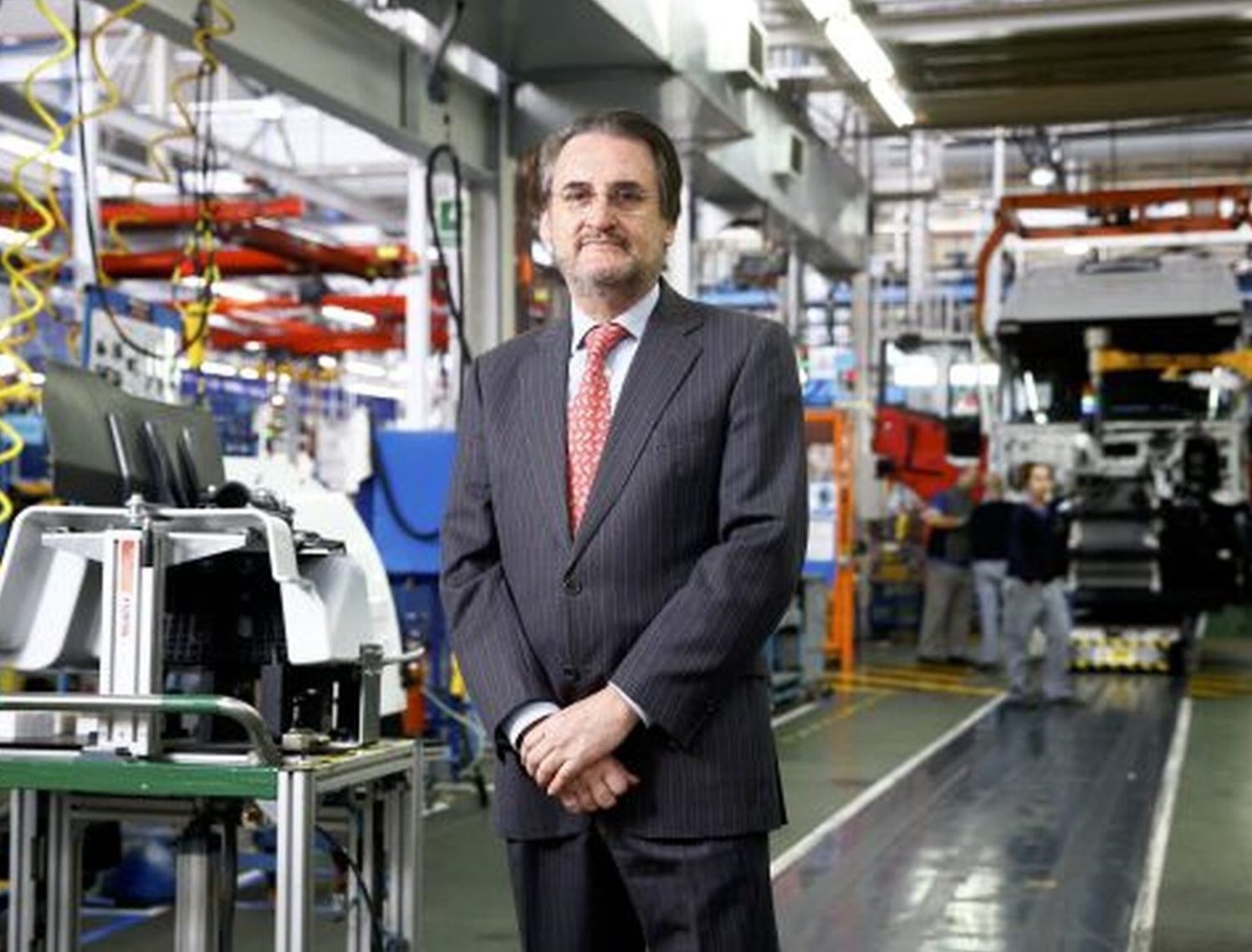 Jaime Revilla de pie en una línea de montaje de vehículos