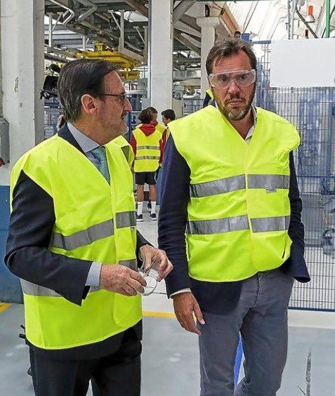 Jaime Revilla y otro hombre con chalecos amarillos de seguridad recorriendo una fábrica